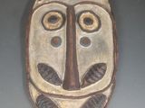 un masque en bois accroché au mur