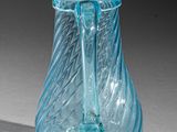 a blue glass vase sitting on a white surface
