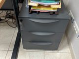 a stack of papers sitting on top of a filing cabinet
