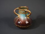 a brown and blue vase sitting on a table