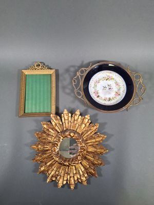 un soleil doré, un miroir et une assiette accrochés au mur