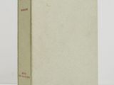 an old book sitting on top of a table next to a white wall