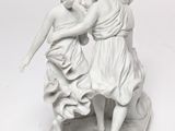 a statue of two women that are playing with each other