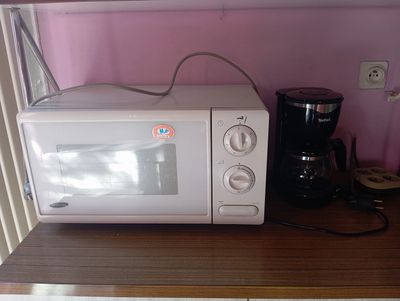 un micro-ondes et une cafetière posés sur une étagère