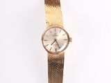 an image of a gold wrist watch with a white face