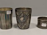 deux tasses en argent et une tasse en argent posées sur une table blanche