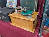 an old record player sitting on a table next to a suitcase