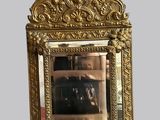 un miroir avec un cadre doré, dans lequel on voit un chien