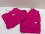 pink nike sweat pants and t - shirt are on a white table