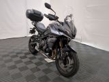 une moto qui est garée dans une pièce dont le sol est en damier