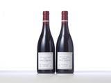 two bottles of red wine sitting on top of a table