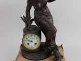 a statue of a woman holding a clock on top of a table