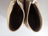 pair of tan sued shoes on a white surface with a white background