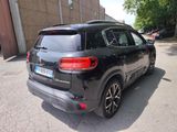 the rear end of a black suv parked on the side of a road
