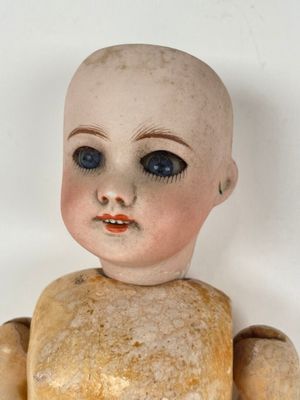 a small doll that is sitting on a white surface