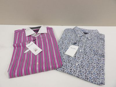 deux chemises pour homme posées sur une table, avec leurs étiquettes encore attachées