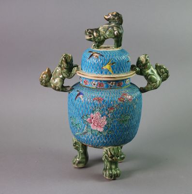 a blue vase with a bird and flowers on it