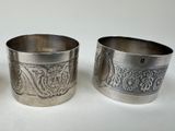 three silver cups sitting next to each other on a white surface