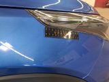 a close up of a car ' s headlight with a sticker on it