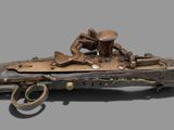 an old gun that is on display on a gray surface