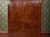 a wooden cabinet with a marble top in the corner of a room
