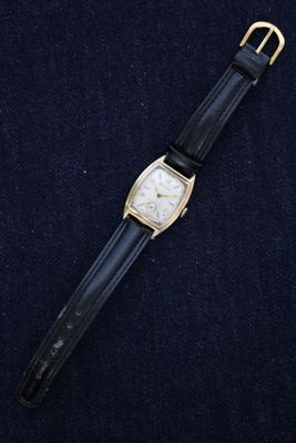 a close up of a watch on a black surface