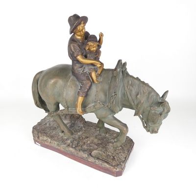 statue en bronze représentant un homme à cheval avec un enfant sur le dos