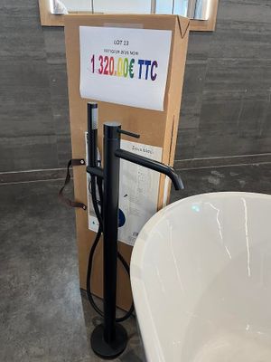 une baignoire blanche placée à côté des toilettes dans une salle de bains