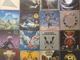 many different album covers on the wall of a room