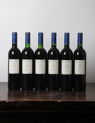 six bouteilles de vin sont alignées sur une table en bois
