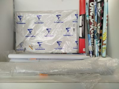 de nombreux rouleaux de papier d'emballage rangés dans une boîte sur une étagère
