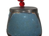 a blue vase with a red ball on top of it
