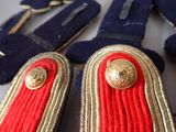 some red and gold buttons and a pair of blue suspends