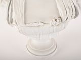 a white busturine of a woman on a pedestal