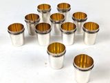 des verres à shot argentés et dorés posés sur un fond blanc