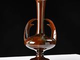 a brown vase sitting on top of a white table
