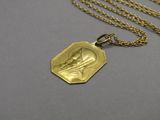 an image of a gold necklace with a picture of a woman on it