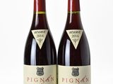 deux bouteilles de vin rouge posées l'une à côté de l'autre sur une surface blanche