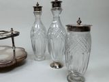 three glass vases and a silver plate on a table