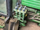 a picture of a green tractor with a bunch of water bottles on it