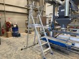 une photo d'une usine avec un tapis roulant au milieu de la pièce