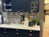 an image of a kitchen with black cabinets and white counter tops