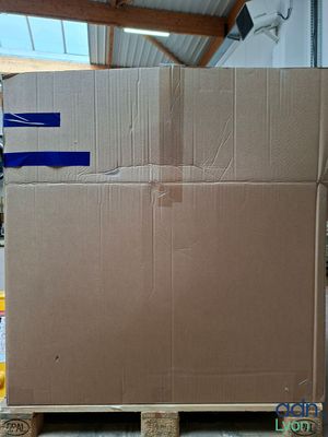 des cartons empilés sur des palettes dans un entrepôt couvert