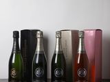 trois bouteilles de vin mousseux sont alignées sur une table