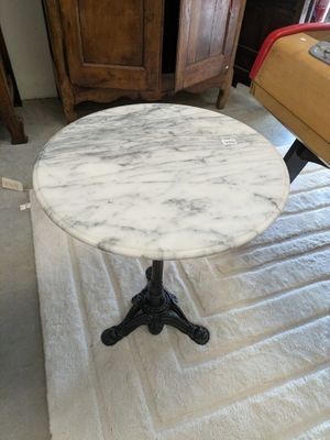 une table en marbre blanc avec un piètement en métal noir