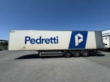 Le semi-remorque est garé sur le parking près du bâtiment.