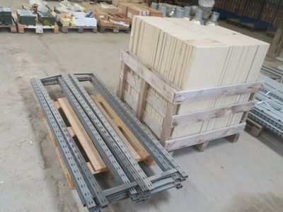 plusieurs palettes de bois sont empilées sur des palettes dans un entrepôt