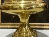 a gold plate on a pedestal with a picture in the background