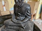 une statue d'un homme assis sur une table