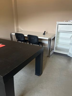 une table noire sur laquelle est collé un autocollant rouge, dans une pièce